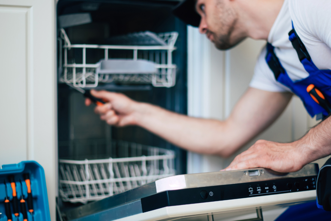 Technician repairing a appliance in a well-kept Carolina Vacays rental home.