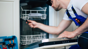 Technician repairing a appliance in a well-kept Carolina Vacays rental home.